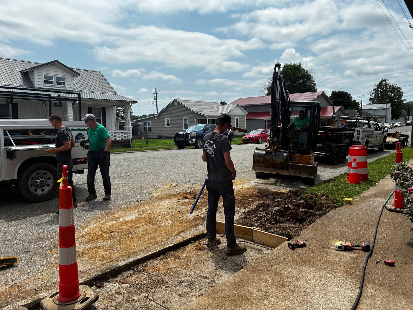 Walsh Plumbing crew and mini excavator working an underground plumbing line in Tell City