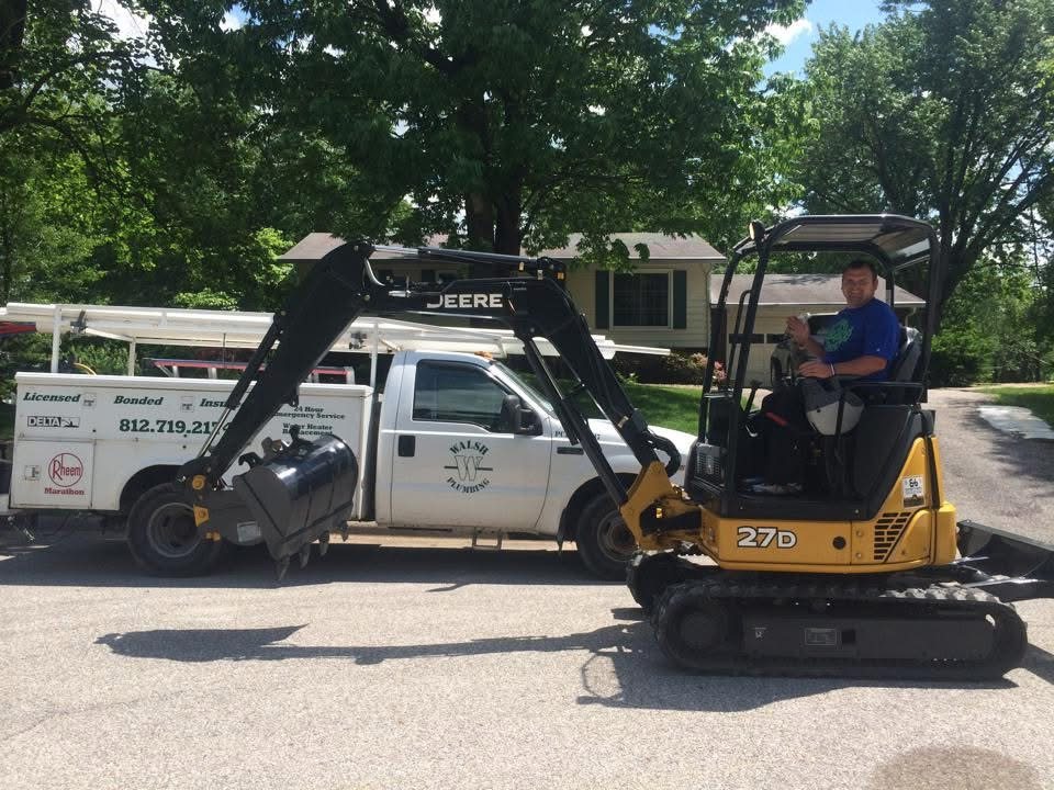 Walsh Plumbing service truck and mini excavator with a technician, licensed bonded and insured signage visible on truck